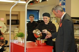Brad Neuenswander, Interim Commissioner of Education with Kansas State Department of Education, worked with Maize High School culinary students Oct. 6 to prepare a balsamic vinaigrette dressing to be served with greens grown by agriculture students.