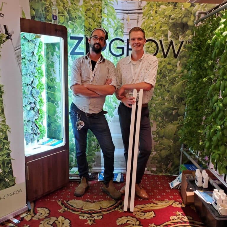 men Infront of a ZipGrow logo, ZipGarden and Greenhouse