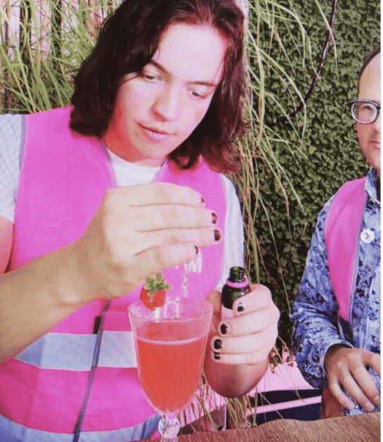 girl adding essence to a pink drink