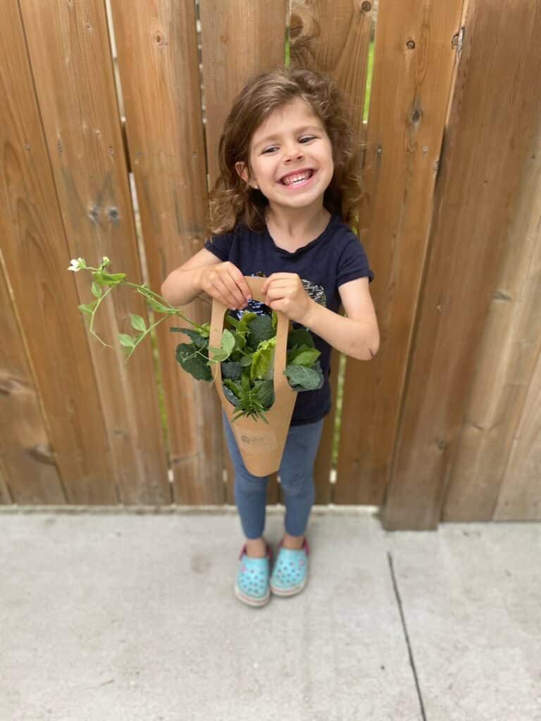 little girl holding a bag of flowers